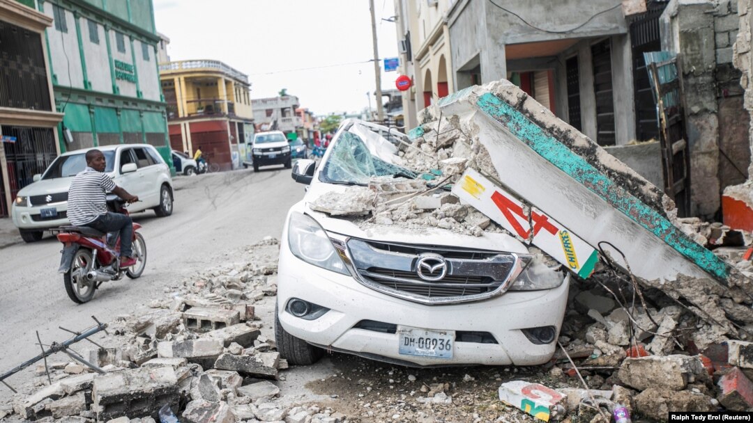 Sebuah mobil rusak di bawah puing-puing setelah gempa berkekuatan 7,2 di Les Cayes, Haiti 15 Agustus 2021. (Foto: REUTERS/Ralph Tedy Erol)