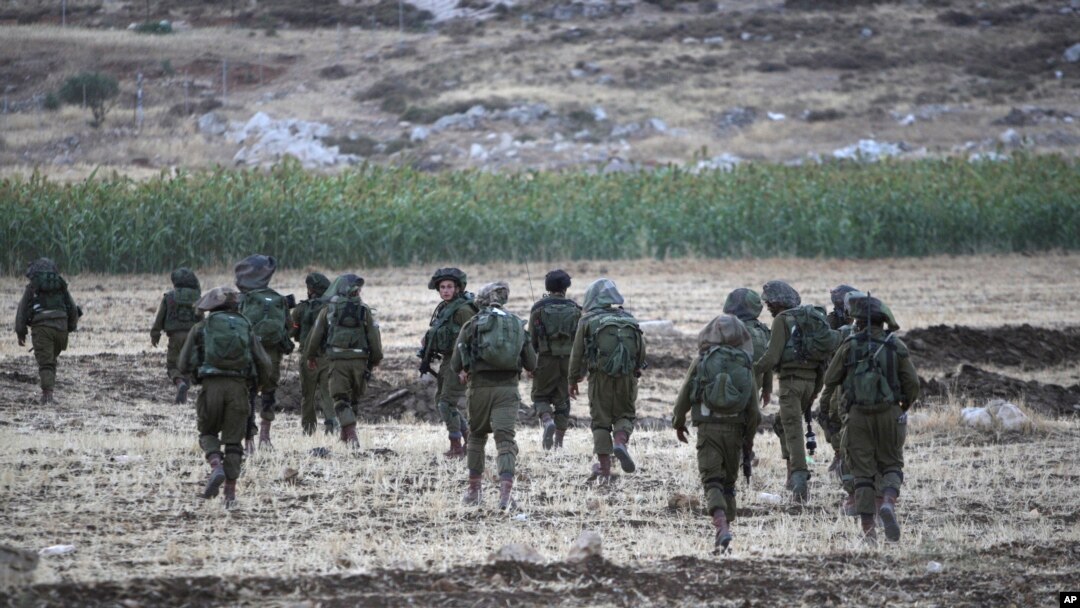 Israeli soldiers walk during an operation near Balata refugee camp in the West Bank city of Nablus,Tuesday, June 17, 2014. 
