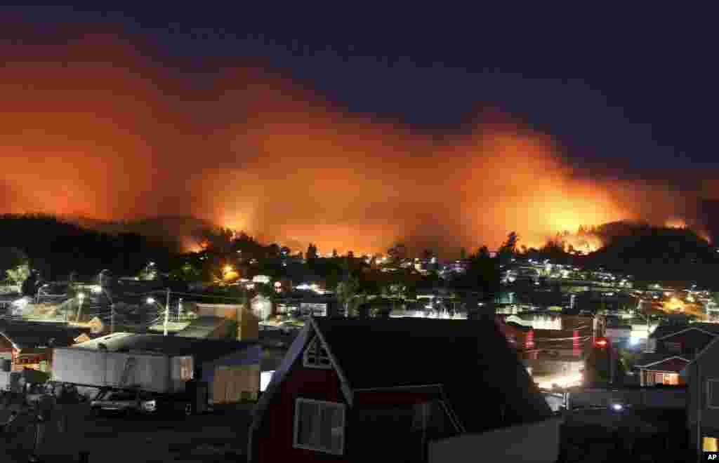 A wildfire approaches Chile&#39;s Dichato community, Jan. 30, 2017, where firefighters are working to keep the flames away from the estimated 800 homes.