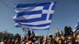 Protesters wave Greek flags outside the Greek parliament during a protest at the 24-hour nationwide general strike in Athens, October 18, 2012. 