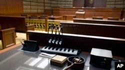 FILE - in a representative illustration, a gavel sits on a desk inside an empty courtroom at a court house. Taken Jan. 14, 2013.