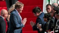 King Willem-Alexander of the Netherlands, center left, performs namaste greeting as he is introduced to Indonesian Foreign Minister Retno Marsudi, center right front, upon arrival in Jakarta, Indonesia, Monday, March 9, 2020. (AP Photo/Dita Alangkara)