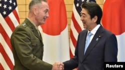 General Joseph Dunford, left, the chairman of the U.S. Joint Chiefs of Staff, shakes hands with Japan's Prime Minister Shinzo Abe at Abe's official residence in Tokyo, Japan, Aug. 18, 2017.