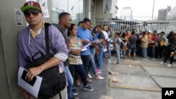 FILE - Venezuelan citizens stand in a line outside the Foreign Ministry office in Lima, Peru, Jan. 23, 2018.