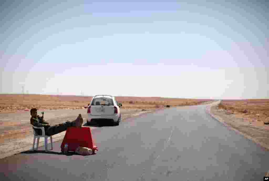 September 8: A former rebel relaxes at a checkpoint in Wai Dinar, Libya. Libya's rebels have surrounded the ousted dictator Moammar Gadhafi, and it is only a matter of time until he is captured or killed. (AP Photo/Alexandre Meneghini)