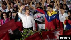 Presiden Nikaragua Daniel Ortega (baju putih) dan Presiden Venezuela Nicolas Maduro bersama memperingati 35 tahun Revolusi Sandinista di Managua Sabtu (19/7). 