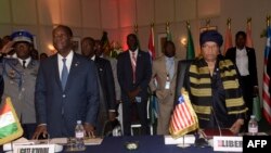 Perezida wa Kote divuwari Alassane Ouattara, mu bubamfu na Perezida wa Liberiya Ellen Johnson, mu uryo. Mu nama ya 49 ya CEDEAO.