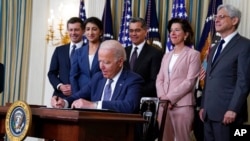 President Joe Biden signs an executive order aimed at promoting competition in the economy, in the State Dining Room of the White House, July 9, 2021, in Washington.