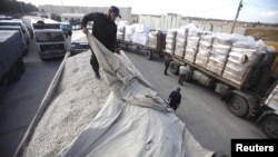 A member of Hamas security forces checks a truck loaded with gravel at the Kerem Shalom crossing between Israel and the southern Gaza Strip, December 30, 2012. 