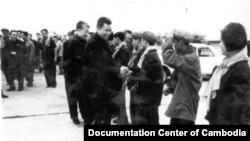 In this undated photo provided by Documentation Center of Cambodia, the late Khmer Rouge leader Pol Pot, center, greets Khmer Rouge cadre in Phnom Penh airport, Cambodia. 