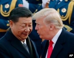 FILE - U.S. President Donald Trump, right, chats with Chinese President Xi Jinping during a welcome ceremony at the Great Hall of the People in Beijing, Nov. 9, 2017.