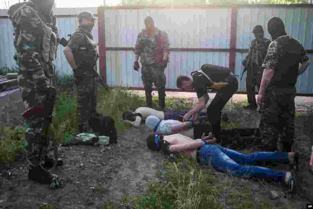 Pro-ruski ekstremisti sa trojicom uhvaćenih muškaraca, koji su navodno špijunirali za vladu u Kijevu. Kramatorsk u istočnoj Ukrajini, 20. maja 2014.