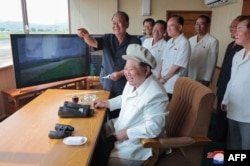 Kim Jong Un (tengah depan) sedang memeriksa uji kinerja pesawat nirawak yang diselenggarakan oleh Institut Pesawat Nirawak Akademi Ilmu Pertahanan di lokasi yang dirahasiakan di Korea Utara. (Foto: KCNA via REUTERS)