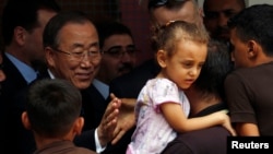 United Nations chief Ban Ki-moon greets a Palestinian man, whose house was destroyed, at a UN-run school for refugees in Gaza City on Oct. 14, 2014.