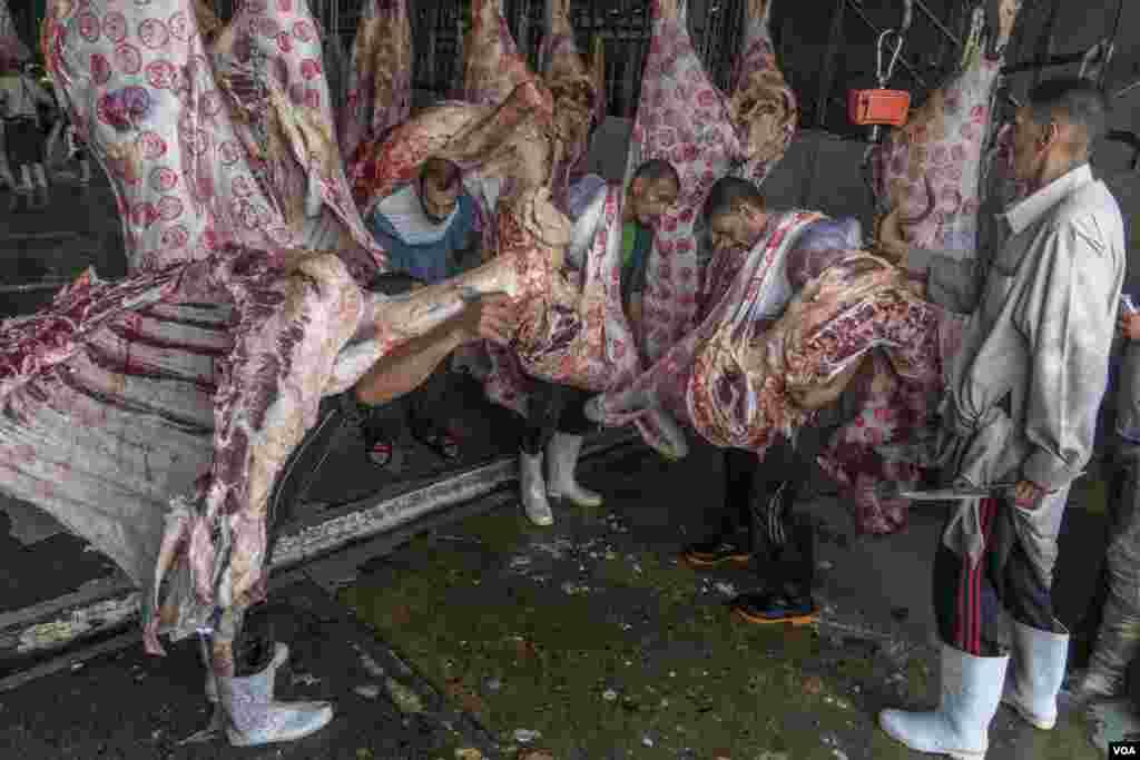 Workers carry meat marked &quot;approved for human consumption&quot; by government inspectors, in Cairo, July 17, 2021. 