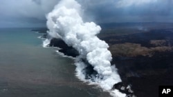 In this May 26, 2018, image from video released by the U.S. Geological Survey, lava sends up clouds of steam and toxic gases as it enters the Pacific Ocean as Kilauea Volcano continues its eruption cycle near Pahoa on the island of Kilauea, Hawaii.