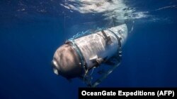 FILE - This undated image courtesy of OceanGate Expeditions shows their Titan submersible beginning a descent. The submersible imploded last year while on its way to the Titanic wreckage. (Handout Photo/OceanGate Expeditions/AFP) 