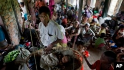 FILE - Internally displaced Rohingya people take shelter in a building ahead of the arrival of Cyclone Mahasen, in Sittwe, northwestern Rakhine State, Myanmar, May 15, 2013. 