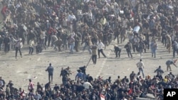 Pro-government demonstrators, below, and anti-government demonstrators, above, clash in Tahrir Square, the center of anti-government demonstrations, in Cairo, Egypt, February 2, 2011