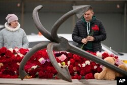 FILE—A man lays flowers at a spontaneous memorial in memory of the victims of Moscow attack in St. Petersburg, Russia, March 24, 2024.