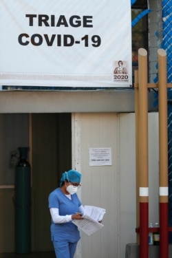 A medical worker from the COVID-19 triage carries paperwork at the Mexico General Hospital, in Mexico City, Tuesday, May 12, 2020.