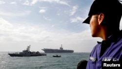 Un marinero filipino ve la llegada del portaviones USS George Washington a Manila, en octubre de 2012. El portaviones arriba este miércoles a Tacloban.