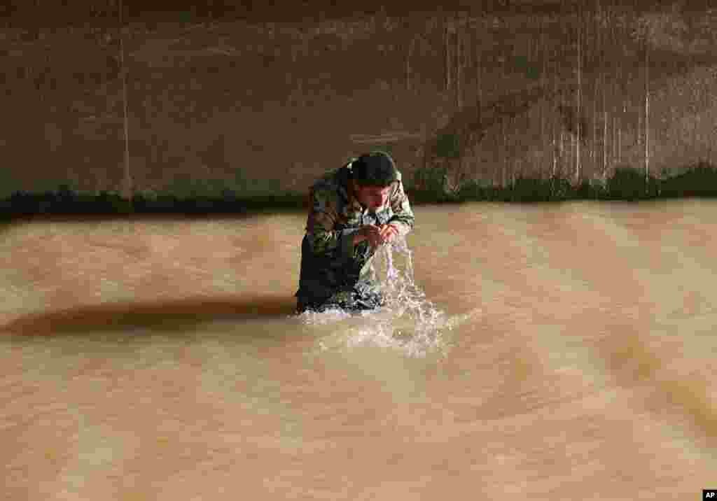 A Kurdish Peshmerga fighter washes in a river under a bridge on the front line with militants from the al-Qaida-inspired Islamic State of Iraq and the Levant (ISIL), in Mariam Bek village, June 30, 2014.