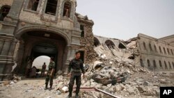 FILE - Shiite rebels, known as Houthis, stand guard in front of Yemen's Defense Ministry building in Sanaa, Yemen on June 10, 2015, after it was damaged by Saudi-led airstrikes. 