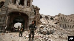 FILE - Shiite rebels, known as Houthis, stand guard in front of Yemen's Defense Ministry building in Sanaa, Yemen on June 10, 2015, after it was damaged by Saudi-led airstrikes. 