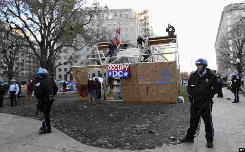 U.S. Park Police guard a structure erected by protesters overnight in McPherson Square, Sunday, Dec. 4, 2011 in Washington. Occupy DC protesters are refusing to dismantle an unfinished wooden structure erected in the Washington, D.C., park overnight.