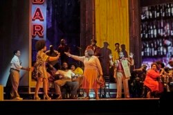 This September 17, 2021 image released by the Metropolitan Opera shows Latonia Moore as Billie, center, and the cast during a rehearsal for Terence Blanchard's "Fire Shut Up in My Bones," the season opening show, on September 27, 2021. (Ken Howard/Met Ope