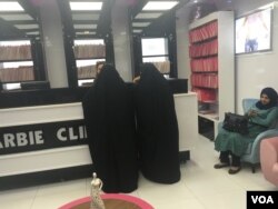 Women in abayas at the counter at Baghdad's Barbie Clinic. (S. Behn/VOA)