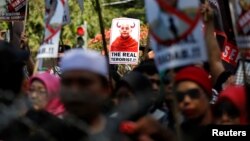 Para demonstran turun ke jalan di Jakarta hari Jumat (8/9) membawa gambar Pendeta Budha radikal Myanmar, Wirathu, dengan tulisan "The Real Terrorist". 