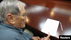 朝中社公布的照片显示美国公民梅里尔.纽曼被朝鲜扣押后在文件上按手印。