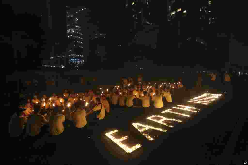 Activists light candles and hold torches as buildings turn their exterior lights off for the Earth Hour at the main business district in Jakarta, Indonesia, March 25, 2017. 