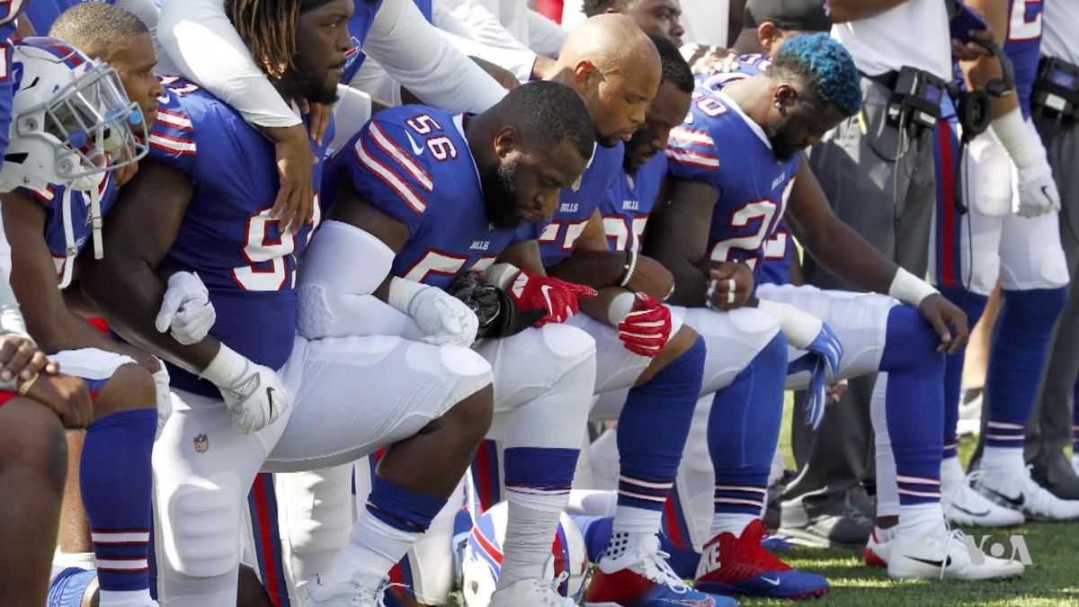 Two Patriots players hold up fists after national anthem