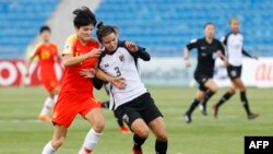 Wang Shanshan berebut bola dengan pemain sepak bola Thailand, Natthakarn Chinwong (kanan) di laga Piala Asia Putri, antara China dan Thailand di Stadion King Abdullah II di Ibu Kota Yordania, Amman, 20 April 2018. 