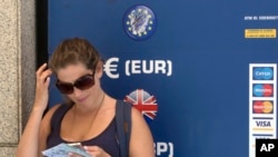 A woman stands by a currency exchange ATM in Madrid, Spain, June 9, 2017. The drop in the British currency had an impact after the British election that produced no clear winner, not just on the local economy but also on companies from around the world doing business in the country as well as tourists and shoppers. 