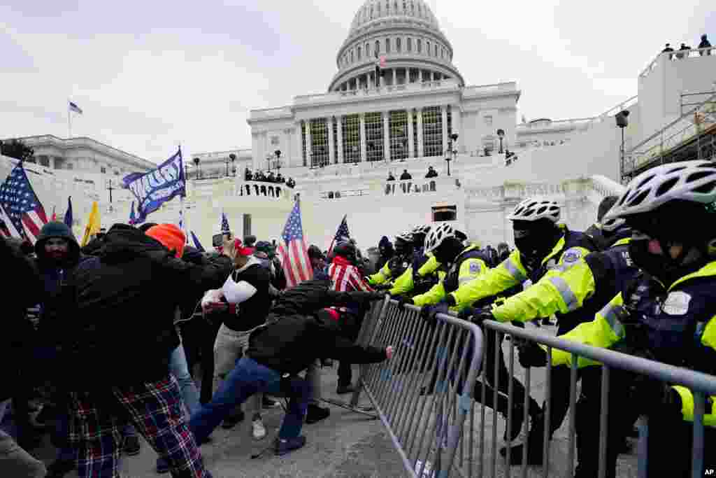 Supporters of President Donald Trump try to break through a police barrier at the Capitol in Washington, Jan. 6, 2021. 
