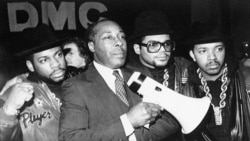 Principal Joe Clark stands with the rap group Run-DMC before the group gave a concert at the school in support of Clark's way of running his school. (AP Photo/Peter Cannata)