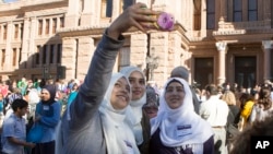Mussarrat Rehman, from left, Rida Syed and Sadaf Karim take a selfie during Texas Muslim Capitol Day, Jan. 31, 2017, at the Texas Capitol in Austin, Texas. 