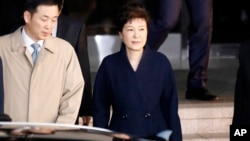 La expresidenta Park Geun-hye, sale de la oficina de la Fiscalía, que ahora busca su detención.