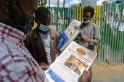 Ethiopians read about the military confrontation in the country, on a street in the capital Addis Ababa, Ethiopia, Nov. 7, 2020.