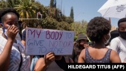 "C'est à moi de donner mon corps, pas à toi de le prendre", lit-on sur une pancarte lors d'une manifestation à Windhoek, le 9 octobre 2020. (Photo: HILDEGARD TITUS / AFP)