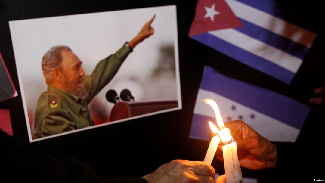 Warga menyalakan lilin di samping foto Fidel Castro, sebagai penghormatan untuk mendiang pemimpin revolusioner Kuba itu, di Tegucigalpa, Honduras (26/11). (Reuters/Jorge Cabrera)