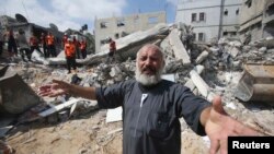 File - A Palestinian man reacts as rescue workers search for victims under the rubble of a house, which witnesses said was destroyed in an Israeli airstrike, in Khan Younis in the southern Gaza Strip, July 2014.