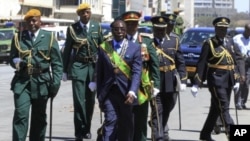 Robert Mugabe deixa o o edifício do Parlamento, ladeado pelos militares