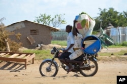 FILE - A couple flees on motorbike from the Jabel area of Juba, South Sudan, July 16, 2016.