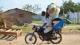 A couple flees on motorbike from the Jabel area of Juba, South Sudan, July 16, 2016. The United Nations refugee agency reports 26,000 people have left the country this month.