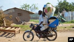 A couple flees on motorbike from the Jabel area of Juba, South Sudan, July 16, 2016. The United Nations refugee agency reports 26,000 people have left the country this month.